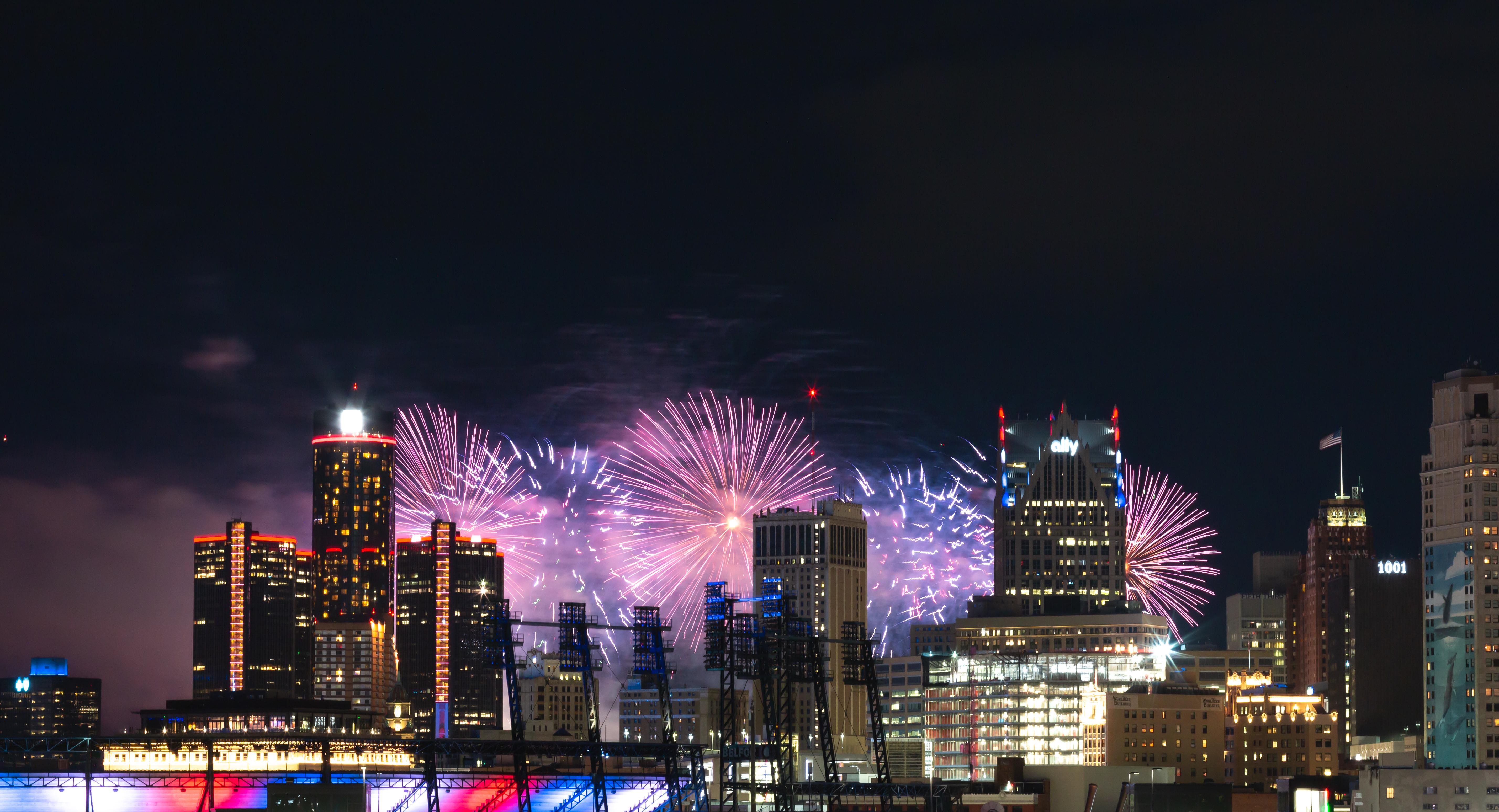 Detroit skyline at night with fireworks in the background.