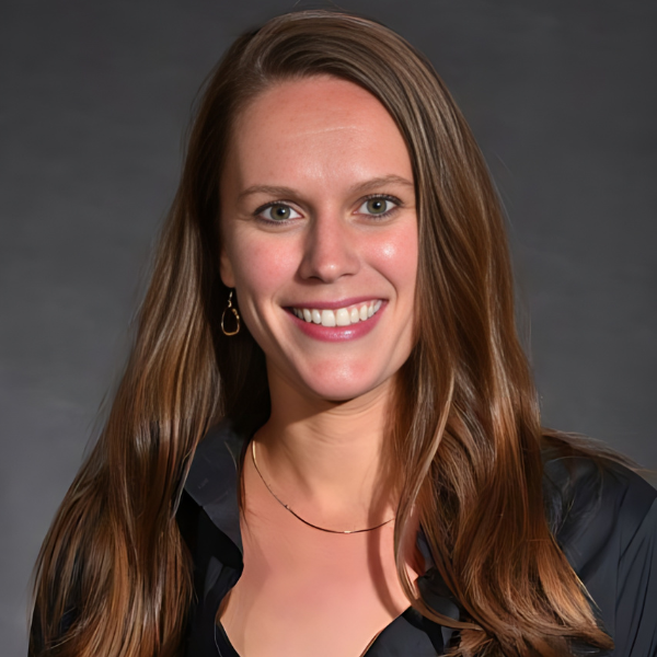 A smiling white woman, with brown hair just past her shoulders and a black shirt