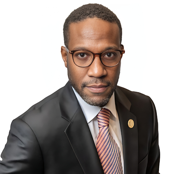 A younger-to-middle-aged African American man with short hair, glasses, a salmon-colored tie, white shirt, and dark gray jacket