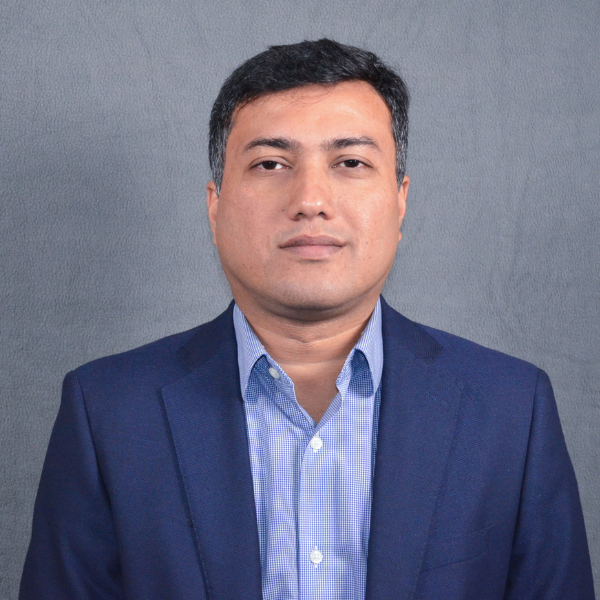 A south Asian man with a dark blue jacket and light blue shirt