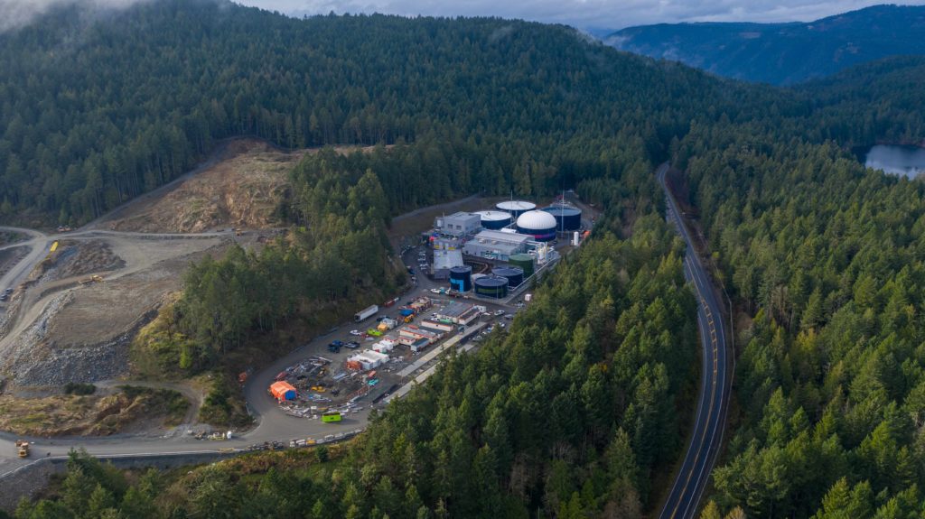 aerial shot of a treatment facility on a narrow site surrounded by hills and trees