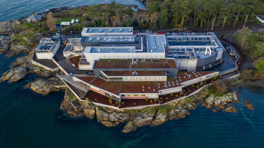 aerial shot of wastewater treatment plant with green roofs located on the waterside